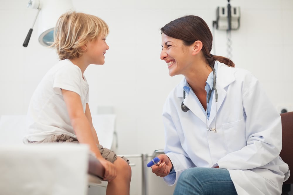 Doctor smiling to a child in examination room